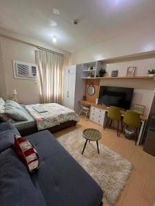 a living room with a couch and a tv at Sunvida Tower - Cebu Stay Rental in Dita