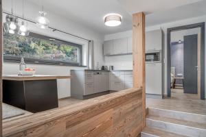 a kitchen with white cabinets and a large window at Corso Living in Sölden