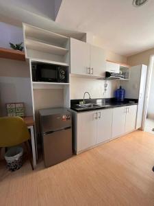 a small kitchen with a sink and a microwave at Sunvida Tower - Cebu Stay Rental in Dita