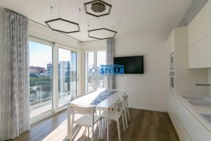 a kitchen with a table and chairs and a large window at Condominio Medusa in Lido di Jesolo