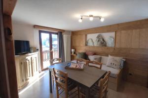 a dining room with a table and chairs and a couch at Appartamento Alta Valle Maira - Provenzale in Villaro