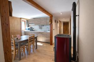 a kitchen and dining room with a table and a refrigerator at Appartamento Alta Valle Maira - Provenzale in Villaro