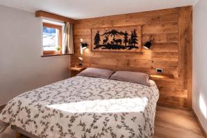 a bedroom with a bed with a wooden wall at Appartamento Alta Valle Maira - Provenzale in Villaro