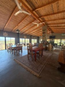 a dining room with tables and chairs in a building at Soeterus Guest Farm in Calitzdorp