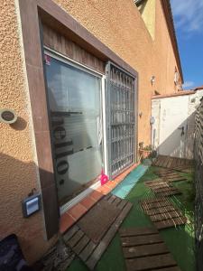 a large sliding glass door on the side of a building at Jacuzzi Clim table de massage jardin et barbecue au cœur de Perpignan in Perpignan