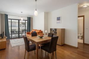 a dining room and living room with a table and chairs at Camélia's Apartment I by An Island Apart, Lda in Funchal