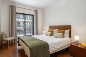 a bedroom with a large bed and a window at Camélia's Apartment I by An Island Apart, Lda in Funchal