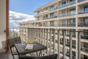 a balcony with a table and chairs and a building at Camélia's Apartment I by An Island Apart, Lda in Funchal
