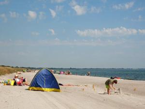 a blue and yellow tent on a sandy beach at 6 person holiday home in Væggerløse in Bøtø By