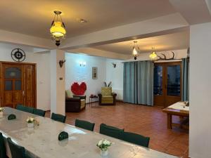 a room with a table and chairs and a living room at Vila dintre Brazi in Moieciu de Jos +38 photos