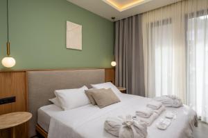 a bedroom with a white bed with towels on it at Monarco Executive Rooms in Rhodes Town