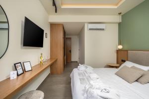 a bedroom with a bed and a tv on the wall at Monarco Executive Rooms in Rhodes Town