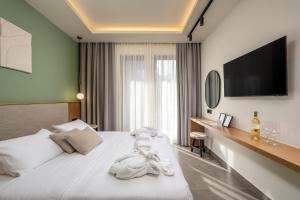 a hotel room with a bed with a flat screen tv at Monarco Executive Rooms in Rhodes Town