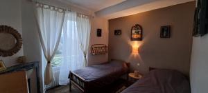 a room with two beds and a window and a lamp at Le Clos du Bohon, 90m2 , calme dans l'Oise ,15 mn de Gisors et son chateau in Labosse