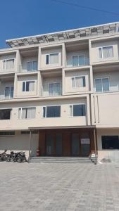 a large white building with a lot of windows at Hotel Golden Bird in Dabok
