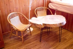 a table with two chairs and a table with a log on it at Mando Homestay in Bắc Yên