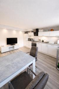 a living room with a table and chairs and a kitchen at Modernes Apartment nahe Frankfurt, Rodenbach & Hanau in Rodenbach