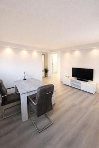 a living room with a dining table and a television at Modernes Apartment nahe Frankfurt, Rodenbach & Hanau in Rodenbach