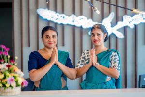 two women standing in front of a mirror praying at Lavendish Hills Kandy in Kandy