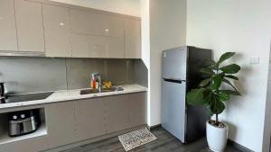 a kitchen with a refrigerator and a potted plant at Homestay đẹp và rẻ r105 in Gia Lâm Pho