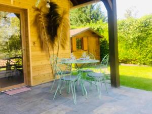 a patio with a table and chairs in front of a cabin at Chalet La Bohème in Prouilly