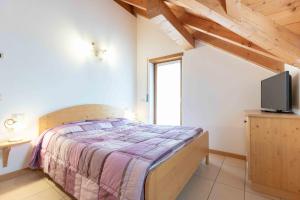 a bedroom with a bed and a tv in a room at Green house in Mezzaselva