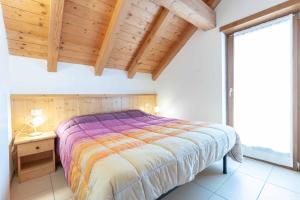a bedroom with a bed and a wooden ceiling at Green house in Mezzaselva