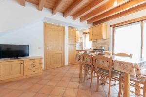 a kitchen with a table and chairs and a television at Green house in Mezzaselva