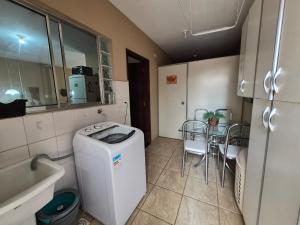 a small kitchen with a washing machine and a table at CASA 230 - Guest House in Piracicaba +60 photos