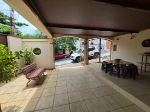 a patio with a bench and a table and a car at CASA 230 - Guest House in Piracicaba