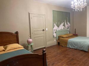 a bedroom with two beds and a chandelier at Casa Bella in Charroux-dʼAllier +18 photos
