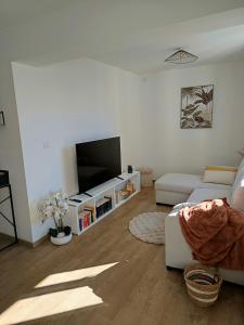 a living room with a couch and a flat screen tv at Porte de secours in Albertville