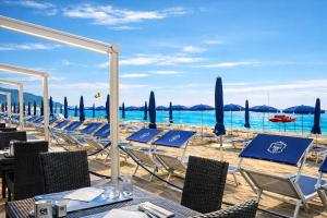 a row of tables and chairs on a beach at LVG Hotel Collection - Grand Hotel Mediterranee in Alassio +205 photos