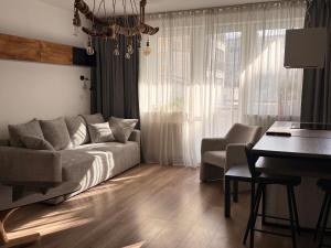 a living room with a couch and a table and a desk at Apartament Katowicka 23 in Poznań