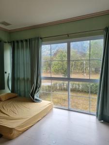 a bedroom with a bed and a large window at Mountain view villa in Vang Vieng