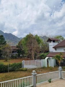 a white fence in front of a house at Mountain view villa in Vang Vieng