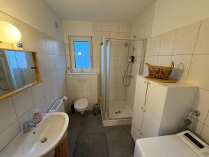 a bathroom with a sink and a toilet and a shower at Casa Tilly - Ferienhaus am Wald in Zwingenberg