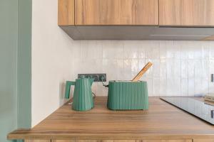 two green containers sitting on top of a kitchen counter at LaBolla, charmant cocon avec spa, cœur de Lyon in Lyon