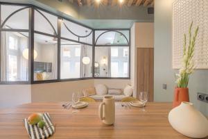 a dining room with a table and a couch at LaBolla, charmant cocon avec spa, cœur de Lyon in Lyon