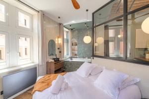 a bedroom with a bed and a bathroom with a tub at LaBolla, charmant cocon avec spa, cœur de Lyon in Lyon