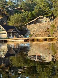 ein Haus am Ufer eines Gewässers in der Unterkunft SOMMERBO- brygge, båt og bil-lader in Kristiansand