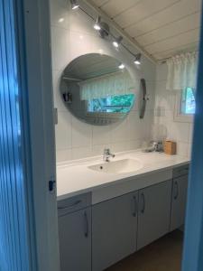 ein Badezimmer mit Waschbecken und Spiegel in der Unterkunft SOMMERBO- brygge, båt og bil-lader in Kristiansand