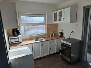 a small kitchen with a sink and a microwave at Bellas place in Yambol