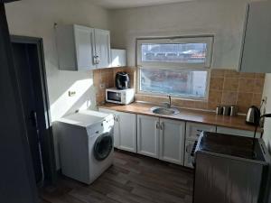 a kitchen with a washing machine and a sink at Bellas place in Yambol +5 photos