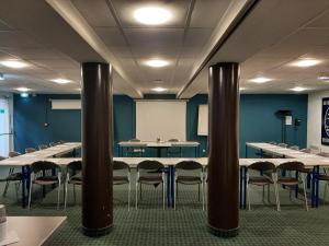 a conference room with tables and chairs and a whiteboard at Brit Hotel Mulhouse Centre in Mulhouse +36 photos