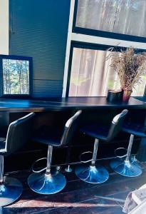a row of stools in a room with a counter at CzarnyGaj in Gaj