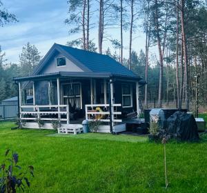 a small house in a yard with a green lawn at CzarnyGaj in Gaj