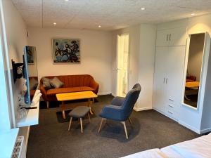 a bedroom with a couch and a table and chairs at Blommenslyst Kro in Blommenslyst