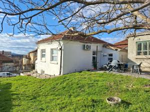 a small white house with a green yard at Bellas place in Yambol