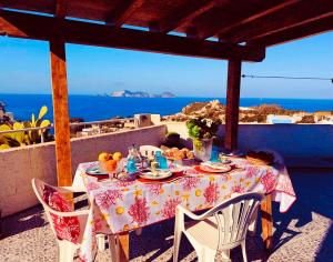 a table on a balcony with a view of the ocean at Ponzamania Terrazza sul tramonto in Ponza +28 photos